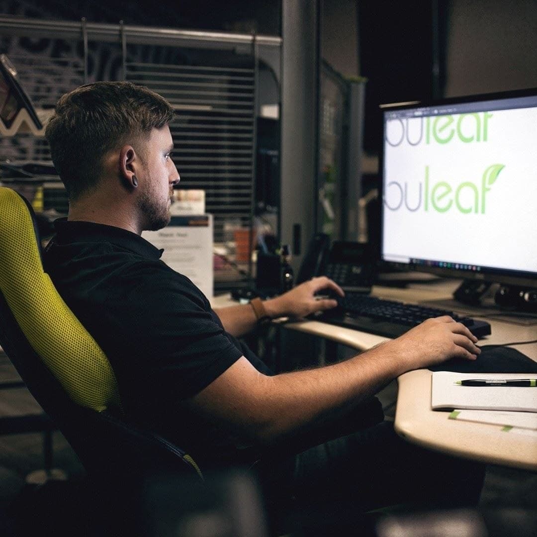Weston Beckwith at a dual-monitor workstation at This Creative, working on a logo