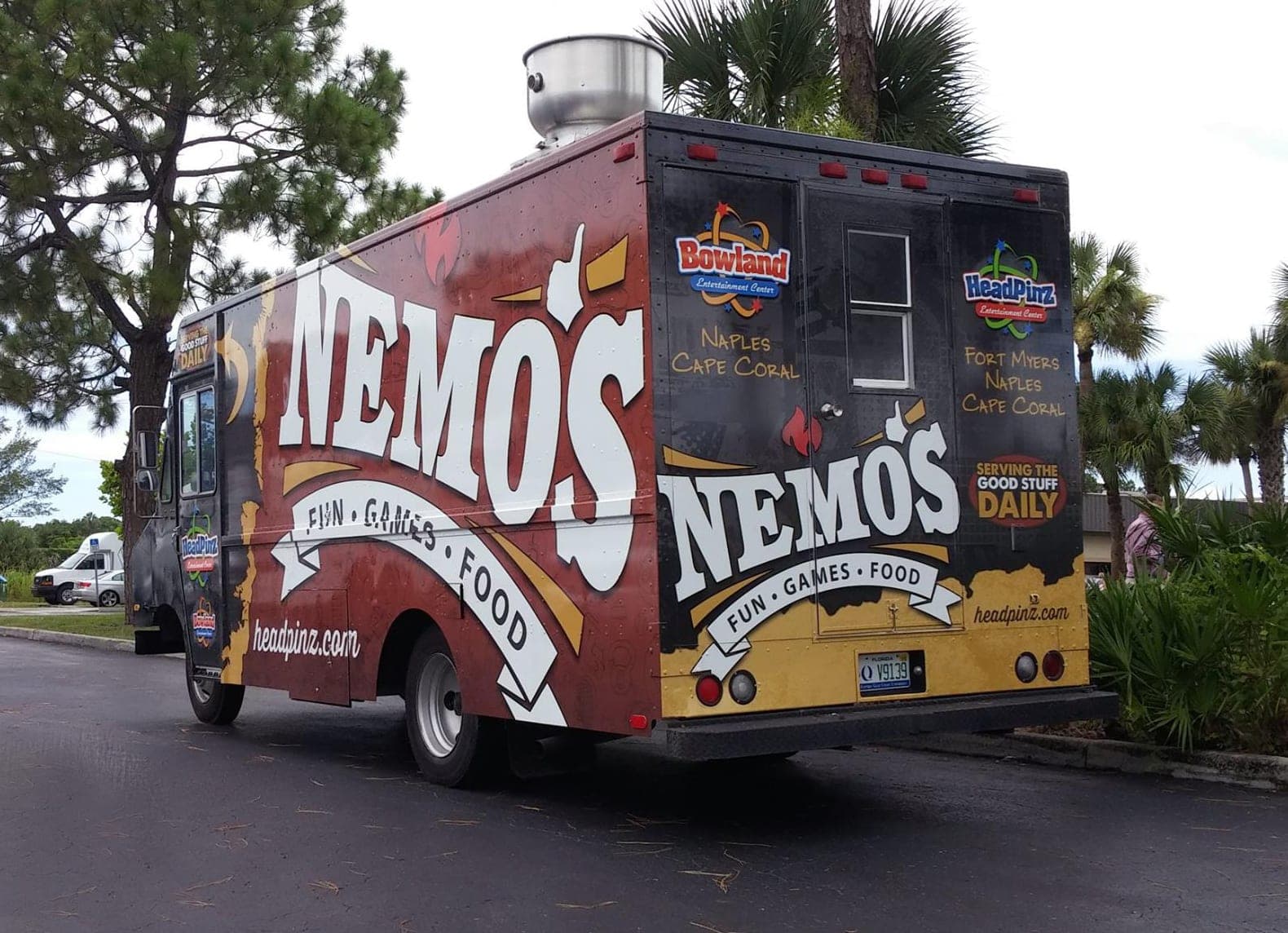 Dark red and black step van wrap for Nemo's Fun Games Food with HeadPinz and Bowland logos, rear angle.