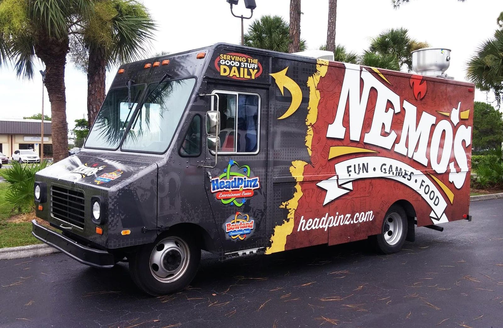 Dark red and black step van wrap for Nemo's Fun Games Food with HeadPinz and Bowland logos, front angle.